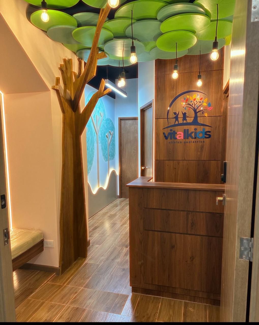 Recepción de VitalKids con el árbol y el logo de la clínica